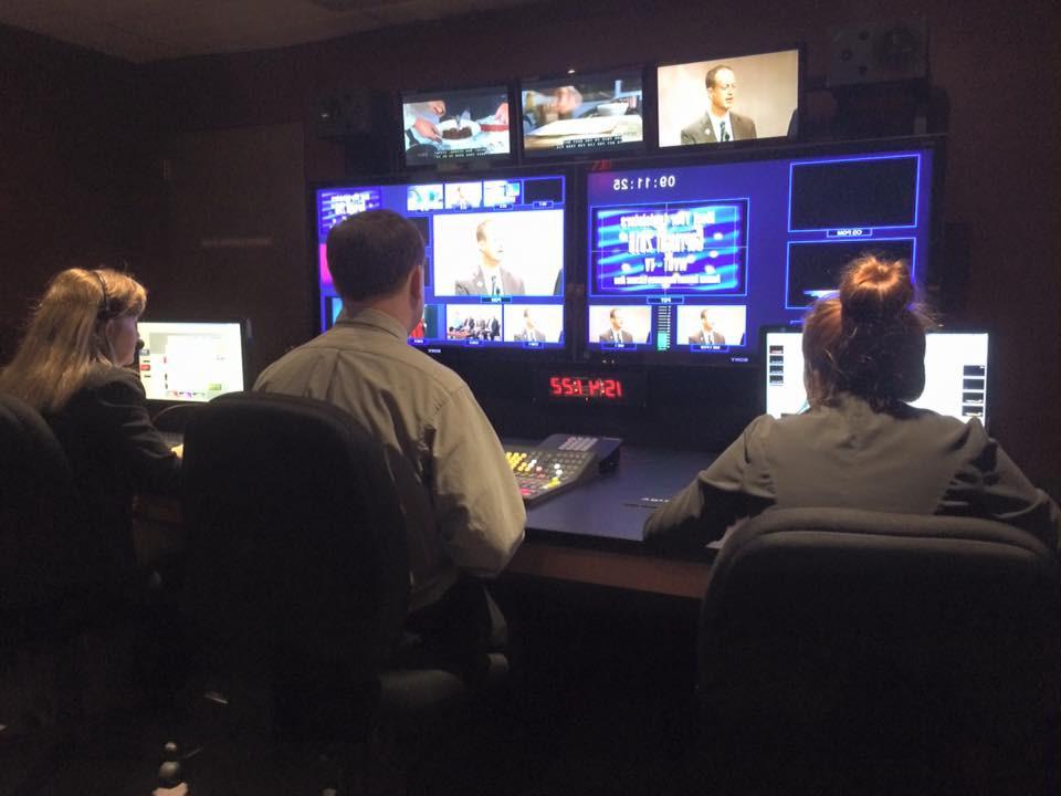 Three workers watching security footage in an office.