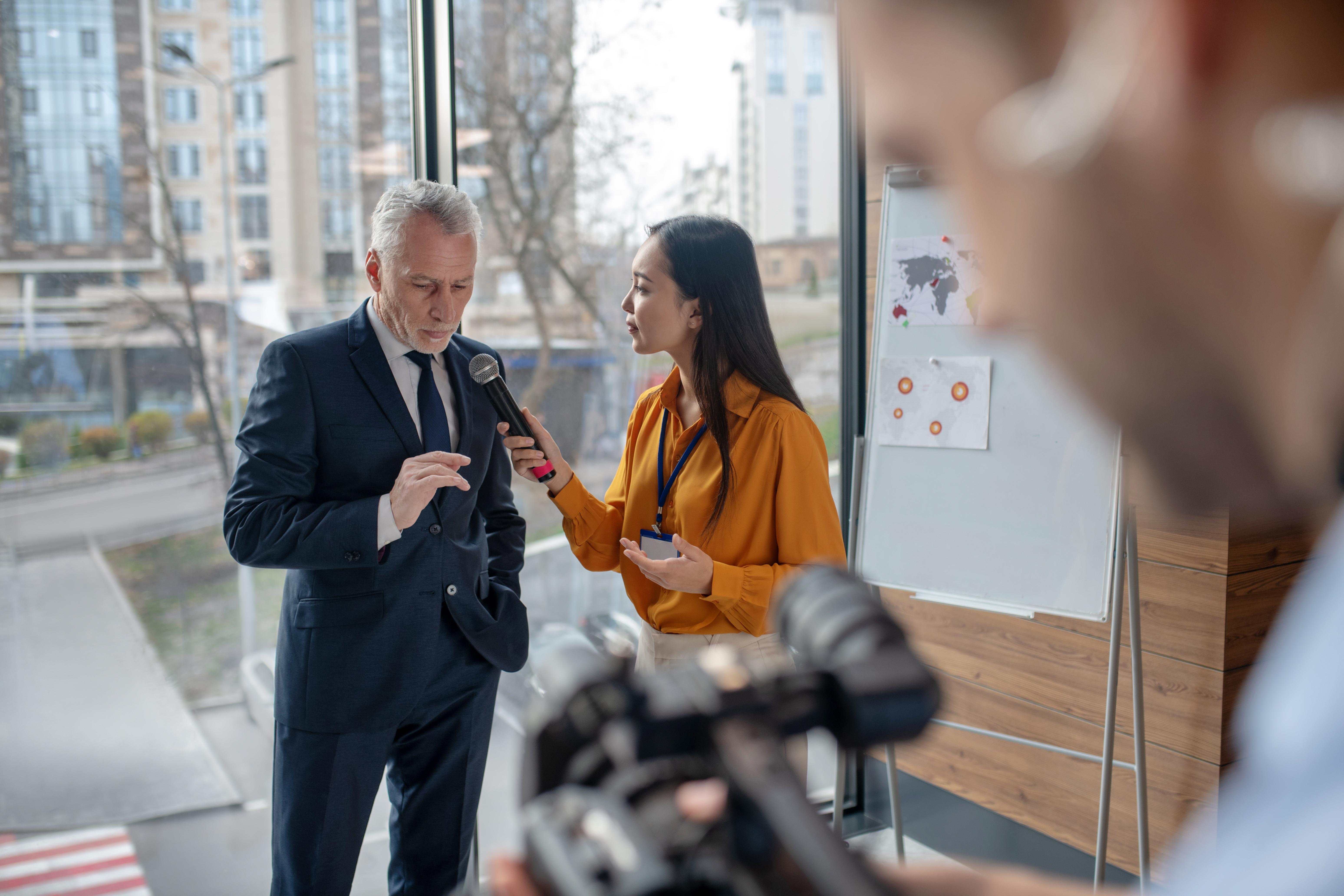 A female reporter interviewing an older man